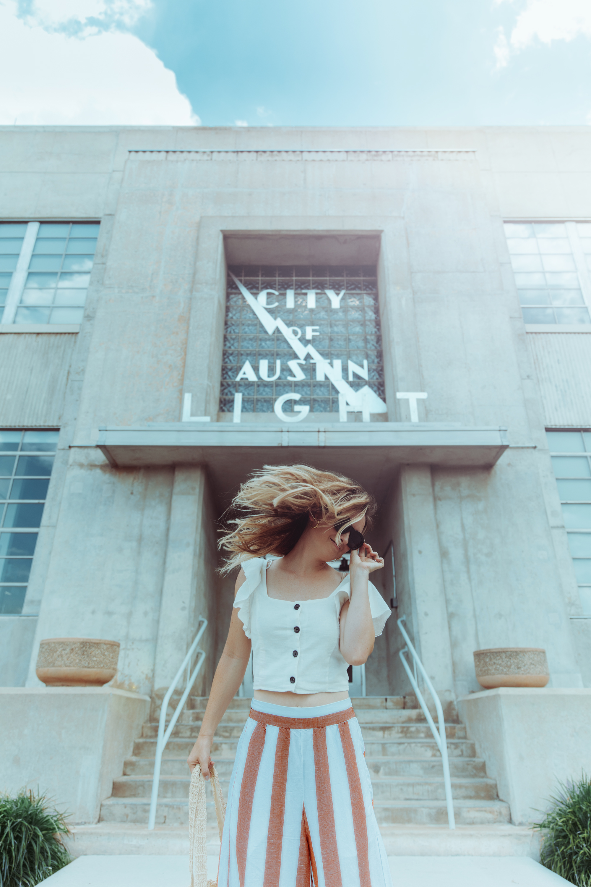 Premium AI Image | A woman in a blue striped shirt and striped pants walks  down an alley