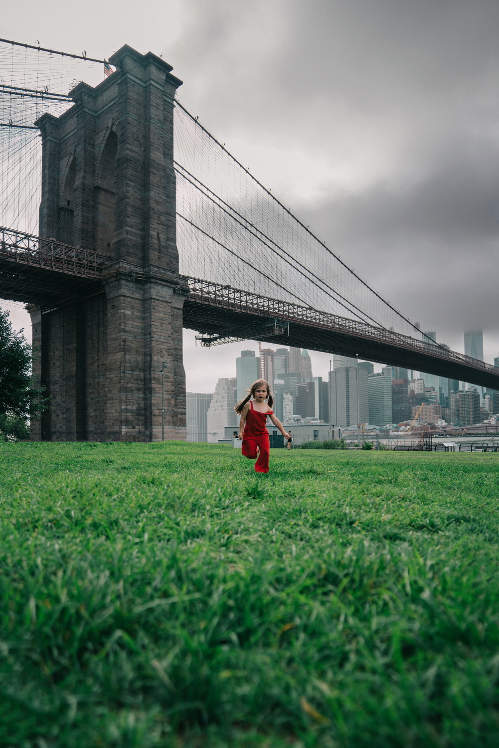 Child running by the Brooklyn Bridge in new york city