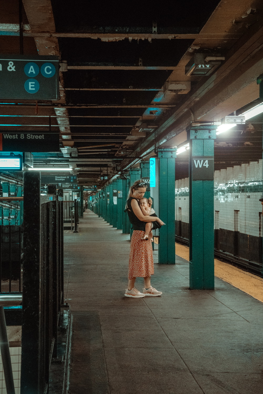 Woman holding a baby on a subway platform