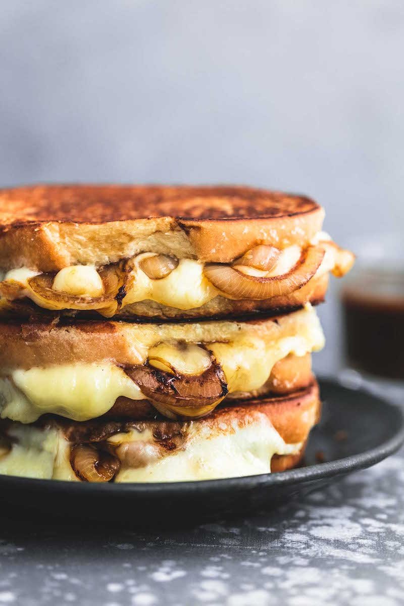 A grilled cheese served on a black plate