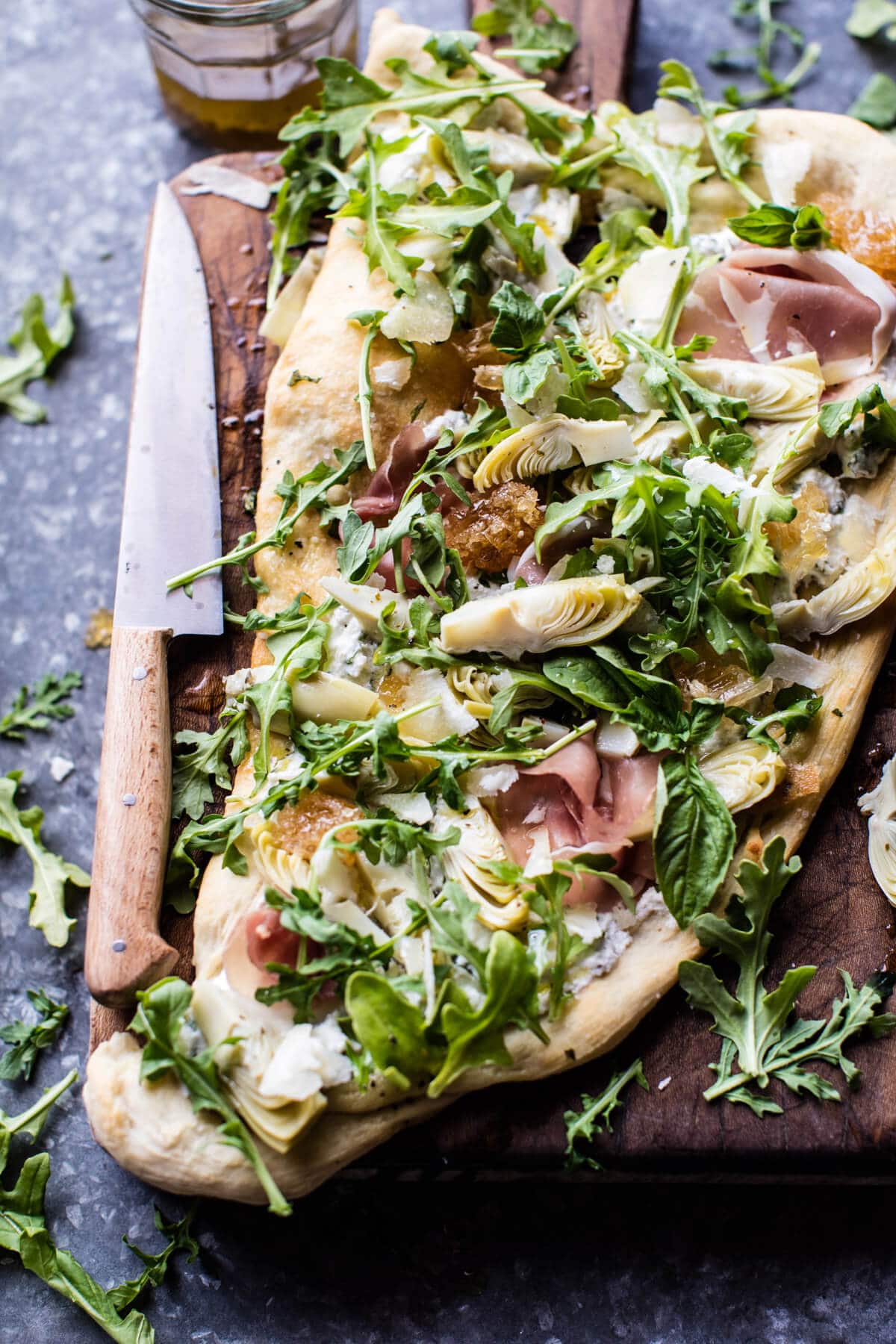 Loaded flat bread on a wooden board