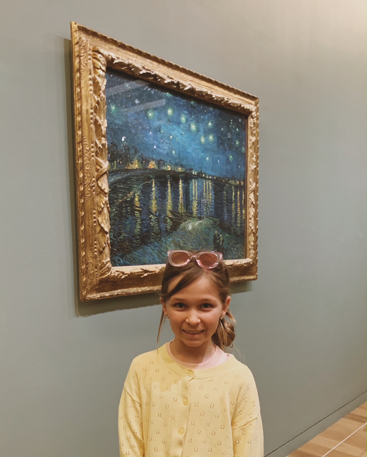 Girl standing in front of Vincent Van Gogh's Starry Night at the Musee D'Orsay in Paris